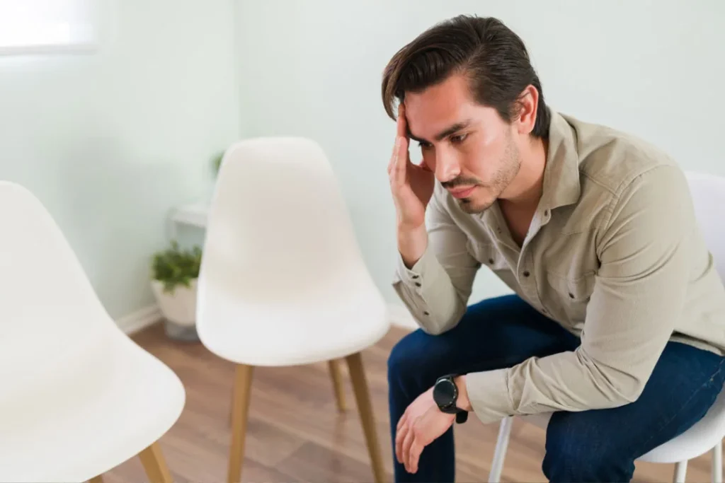 A young man siting on a chair as being sad.