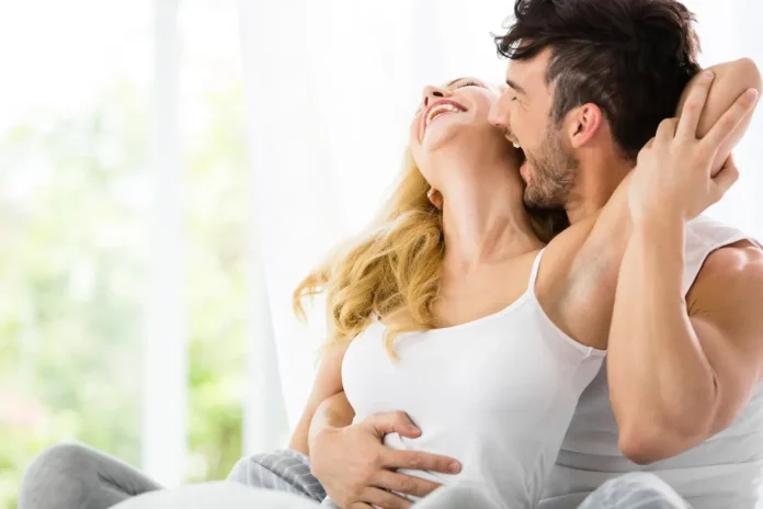 Man and woman kissing each other in bed.