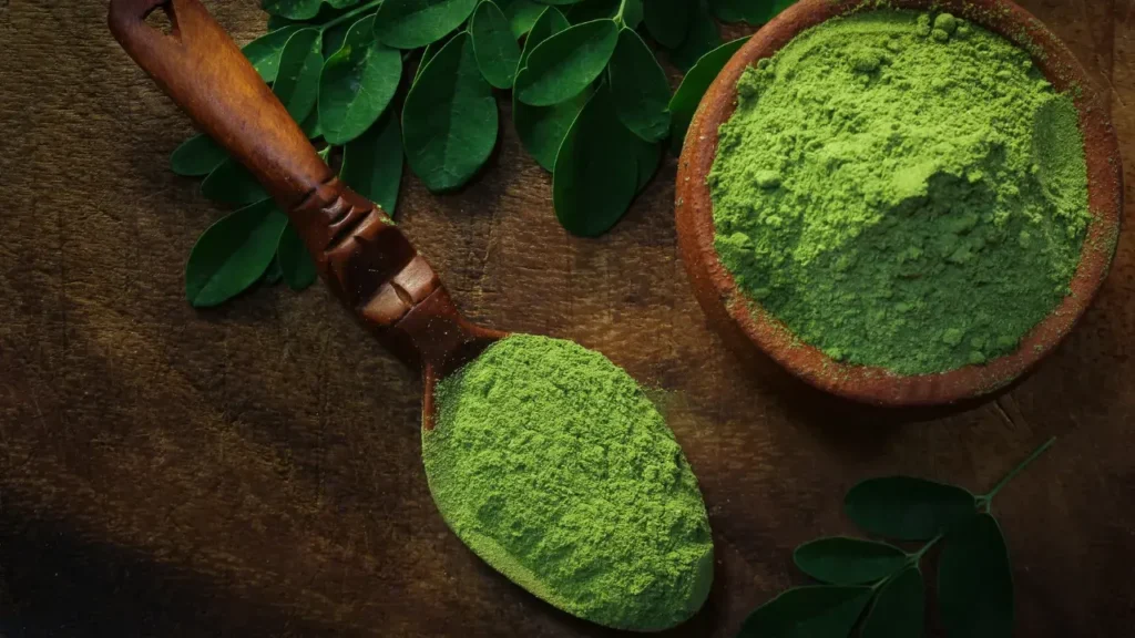 moringa powder in bowl and wooden spoon